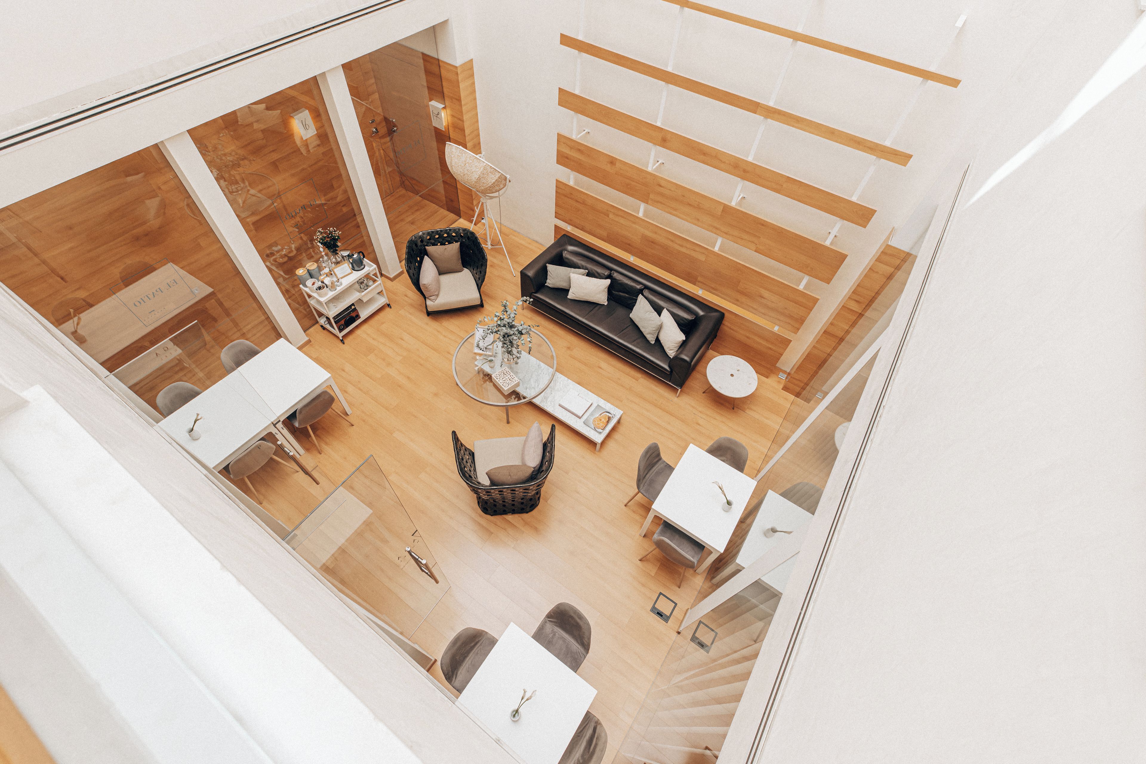 Un interior moderno con una zona de estar, una mesa de comedor y una escalera.