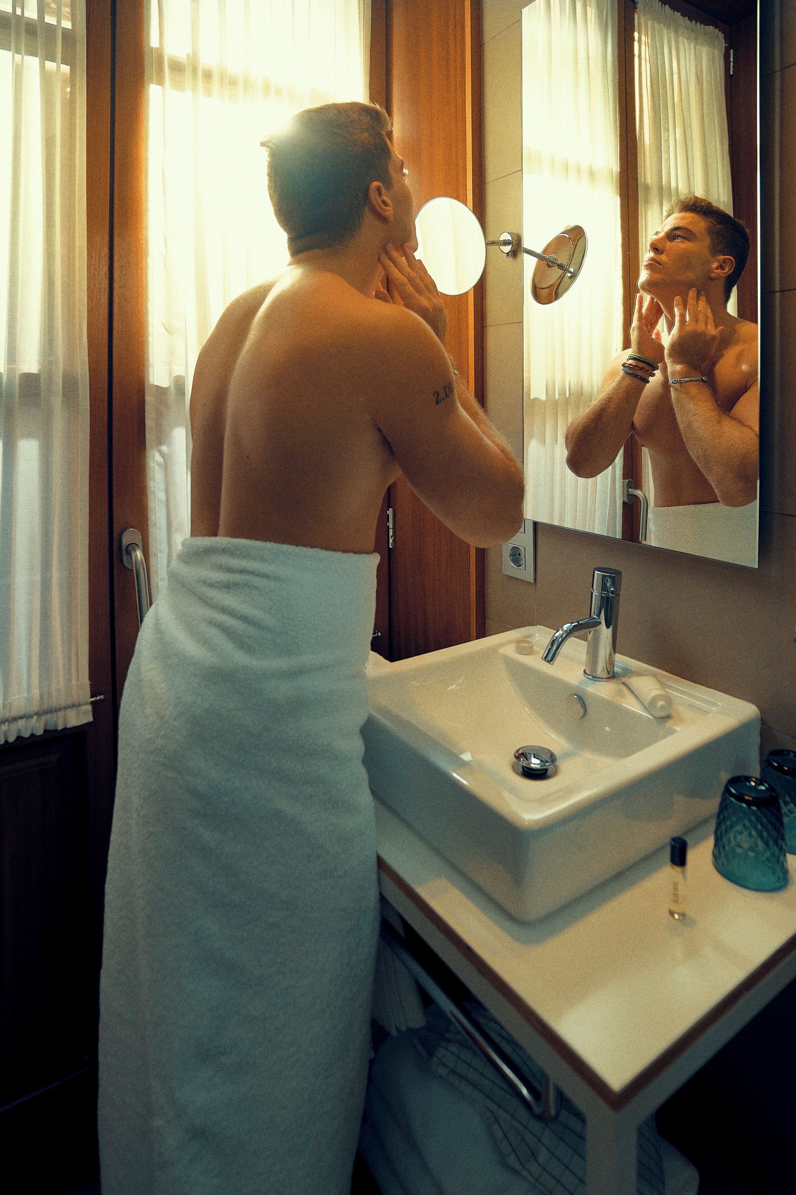 A bathroom with a sink, mirror, and towel rack.