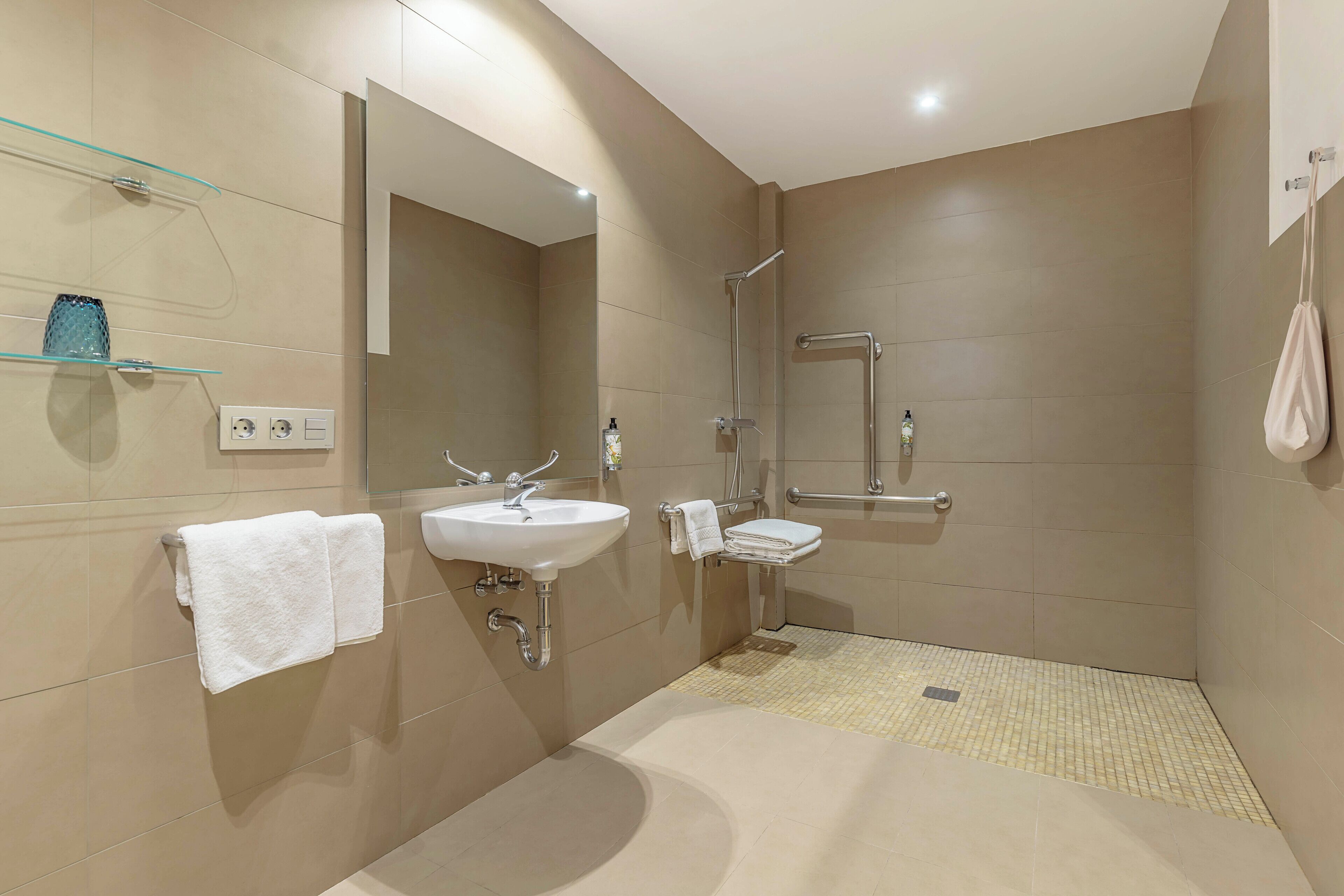 A modern bathroom with a sink, mirror, and shower.