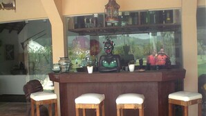 A bar area with stools and a counter. - Pousada do Golfista (Guaruja)