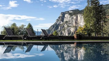 Una piscina cubierta, una piscina al aire libre, sombrillas, tumbonas