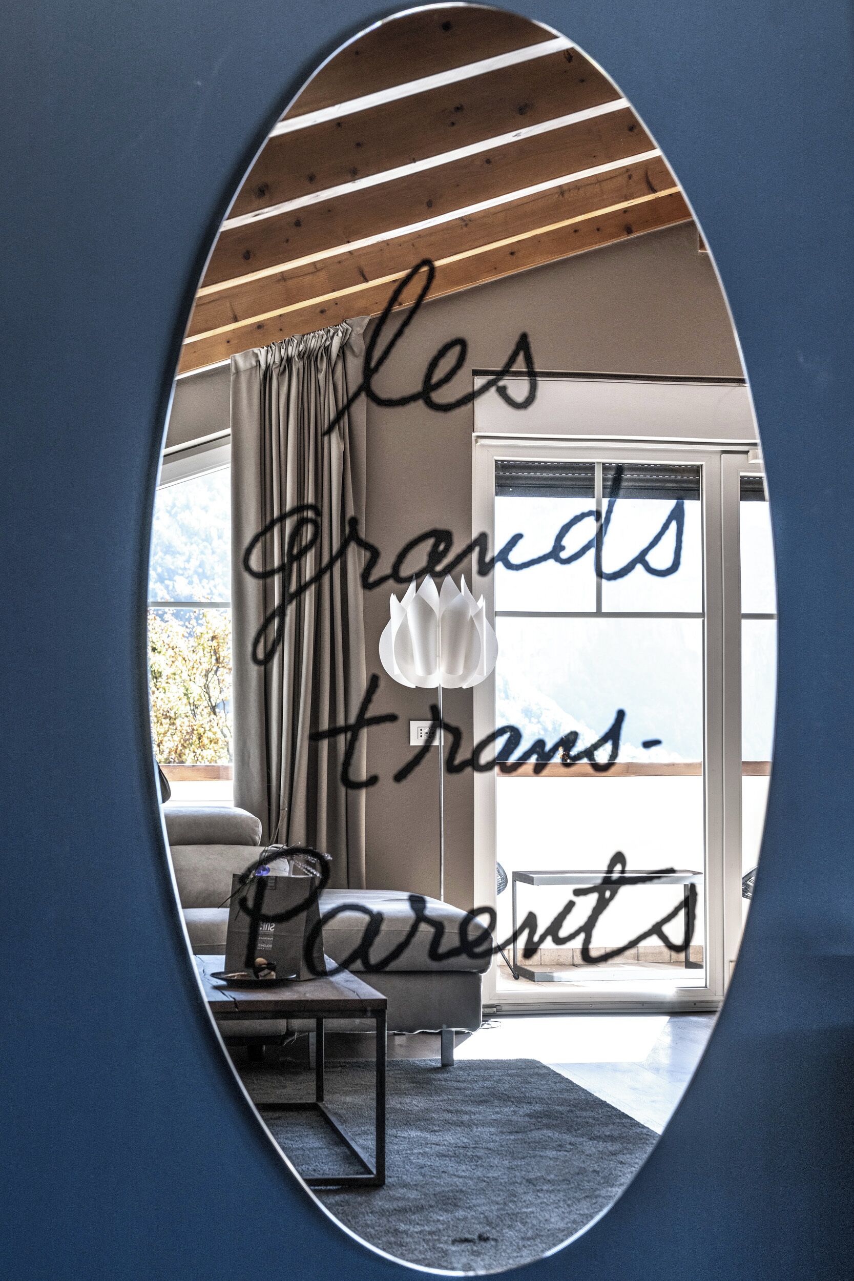 An interior view through a mirror with a handwritten message on the wall.