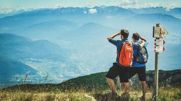 Two people standing on a mountain with a signpost in the foreground.
