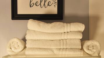 A bathroom with a framed sign above a towel rack and a decorative towel with a geometric pattern.