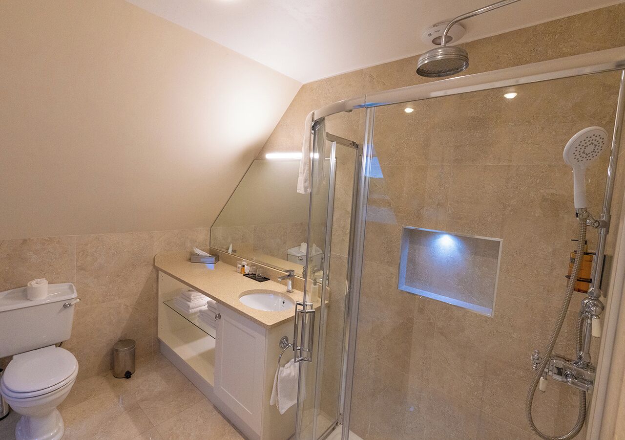 Une salle de bain moderne avec une douche à parois de verre, des toilettes et un lavabo avec un miroir au-dessus.