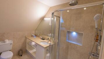 Une salle de bain moderne avec une douche à parois de verre, des toilettes et un lavabo avec un miroir au-dessus.