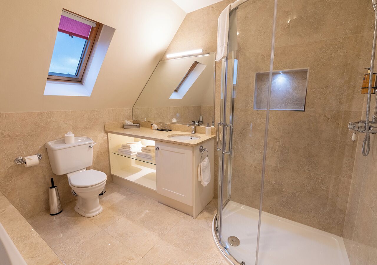 A modern bathroom with a shower, toilet, and sink.