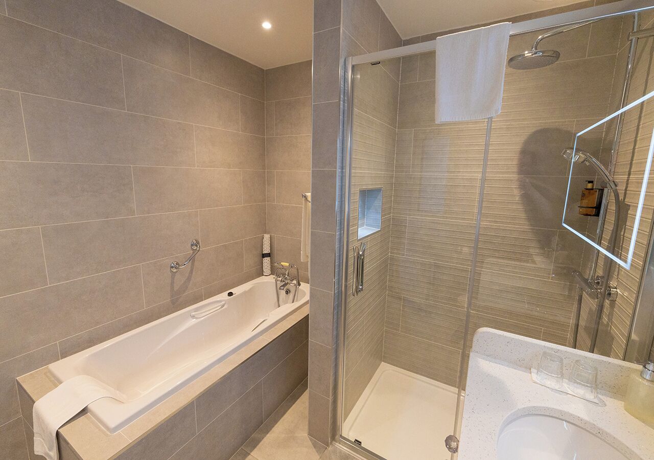 Ein modernes Badezimmer mit Badewanne, Dusche und Waschbecken.