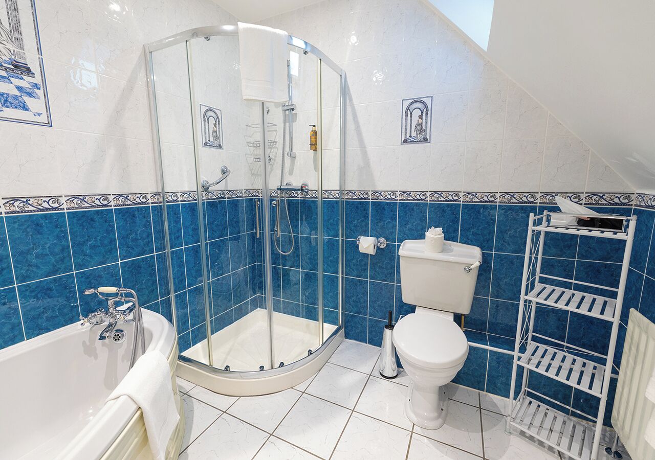 Un baño con ducha de vidrio, inodoro blanco y bañera.