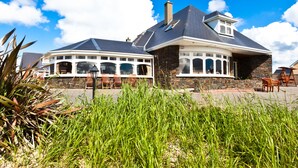 Een huis met twee verdiepingen, een stenen gevel en een ruime garage.
