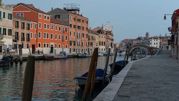 Um canal com barcos atracados, uma ponte e edifícios coloridos à beira da água.