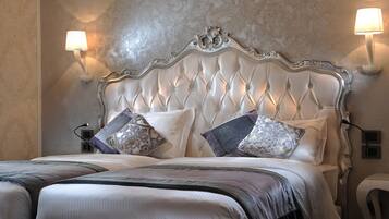 A bed with a tufted headboard, two wall-mounted lamps, and a bedside table with a lamp.