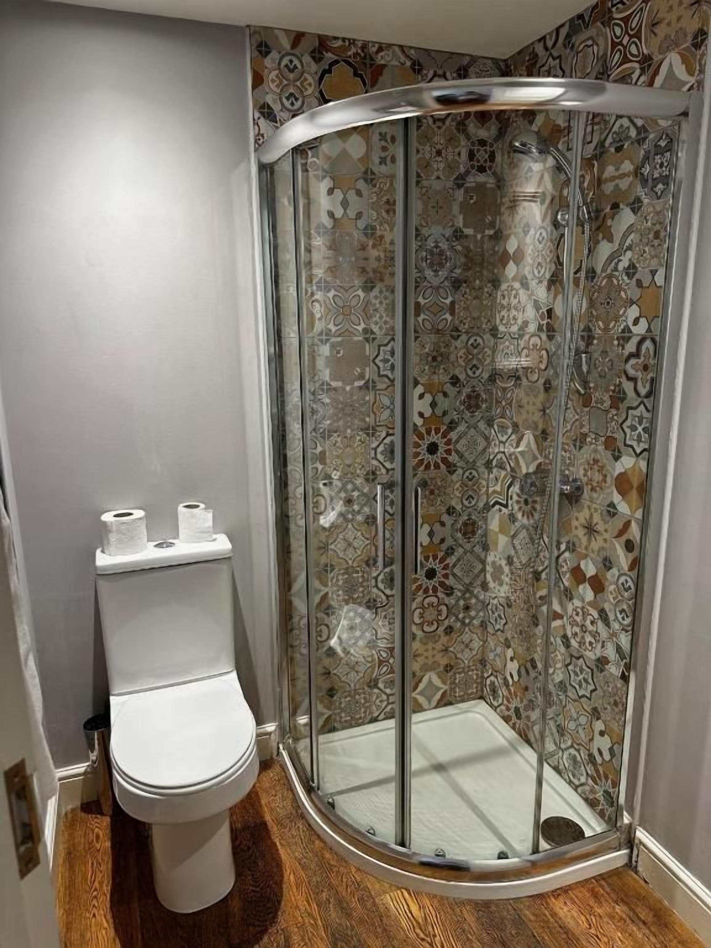 A shower enclosure with a glass door and a showerhead.