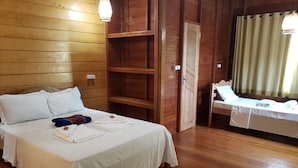 Una habitación con paneles de madera, una cama, una mesita y una silla.