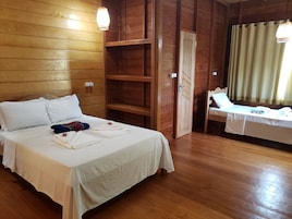 Una habitación con paneles de madera, una cama, una mesita y una silla.