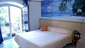 A bedroom with a bed, a view of the outdoors, and a wall mural.