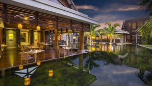 A modern hotel with a pool, outdoor seating, and a covered patio area. - Crystals Beach Resort Belle Mare, a member of Radisson Individuals (Belle Mare)