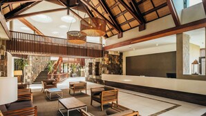 A spacious lobby with a high ceiling, wooden furniture, a reception desk, and a staircase leading to upper floors. - Crystals Beach Resort Belle Mare, a member of Radisson Individuals (Belle Mare)