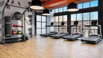 A gym with treadmills, weights, and a punching bag.