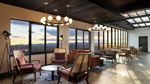 A spacious lounge with large windows, modern furniture, and a skylight. - Aloft by Marriott Asheville Downtown (Asheville)