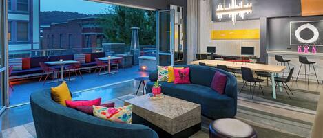 Un área de estar moderna con asientos, una mesa de centro y vistas al exterior.
