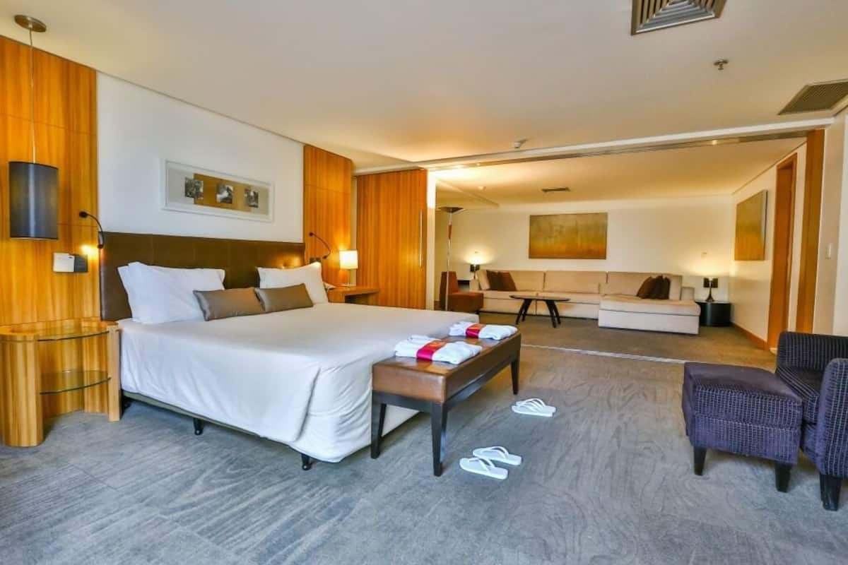 Una habitación de hotel con una cama grande, un escritorio, un sofá y una silla.