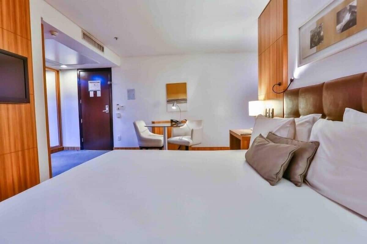 Una habitación de hotel con una cama grande, un escritorio y una silla.
