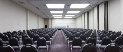 A conference room with rows of chairs facing a whiteboard at the front.