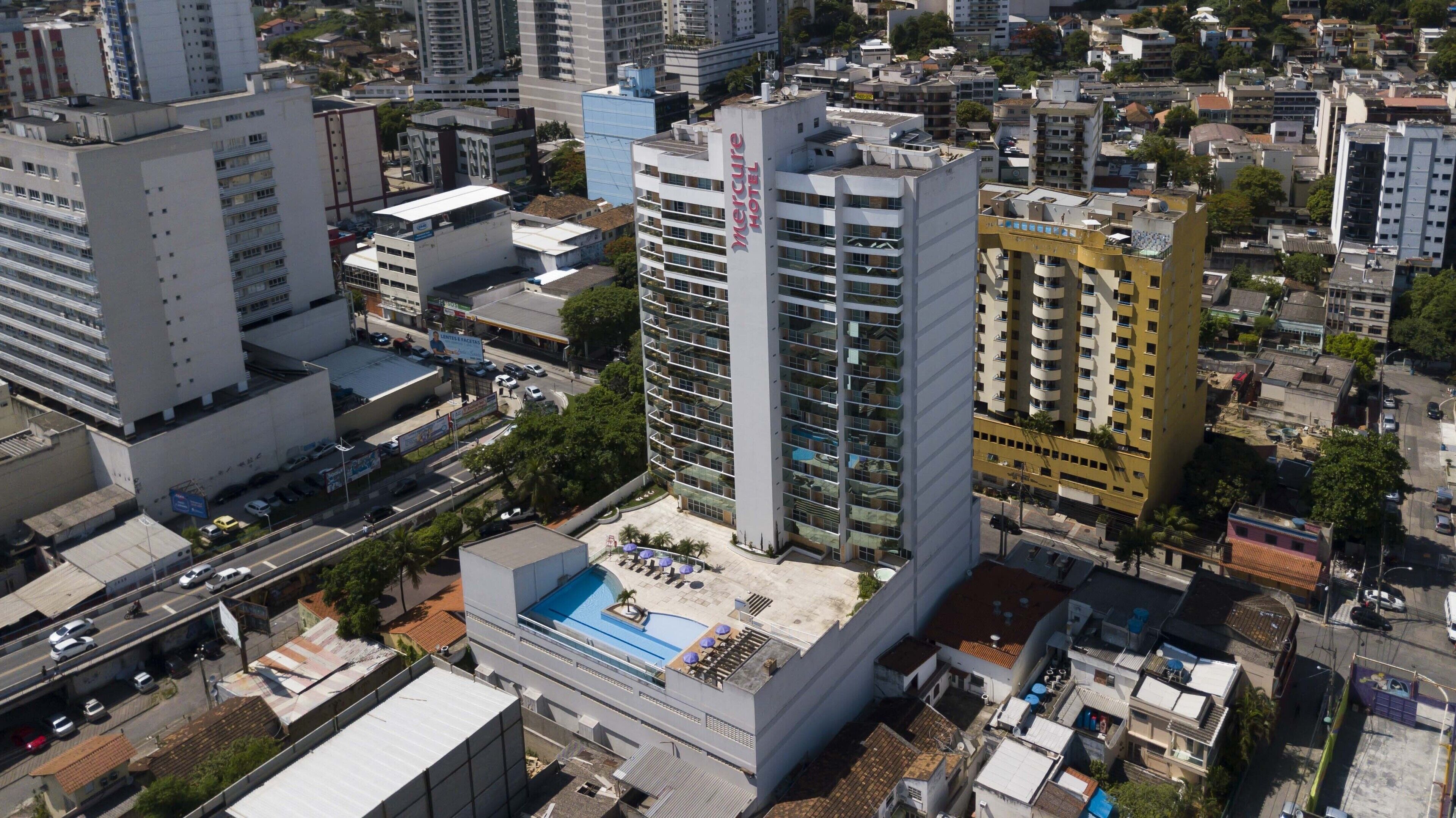 A high-rise hotel with a rooftop pool and multiple balconies.