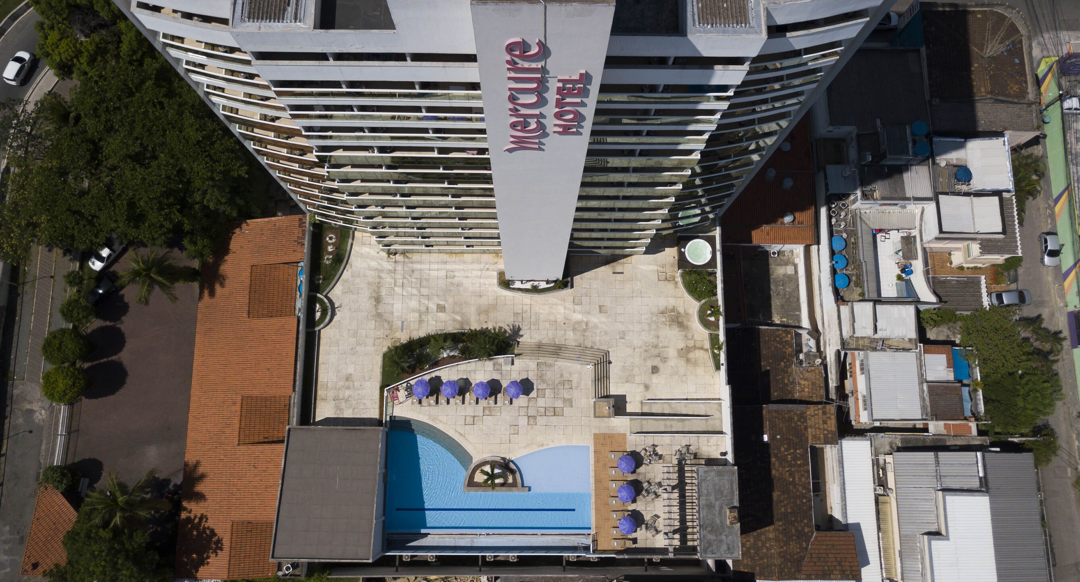 Un hotel de gran altura con piscina y zona de descanso en la azotea.