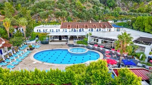 Ein Resort mit großem Pool, mehreren Liegebereichen und einer Esssterrasse.
