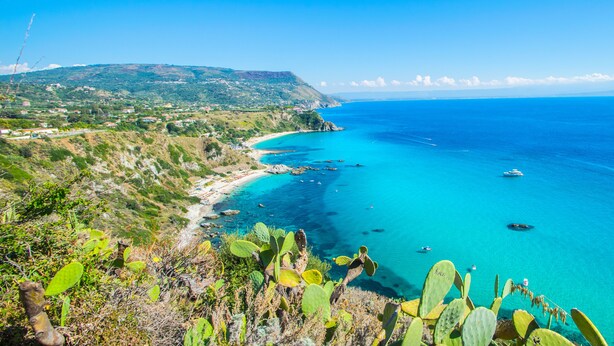 A coastal landscape with a clear view of the sea, a boat, and a mountainous backdrop. - Resort Hotel Rocca di Vadaro (Ricadi)