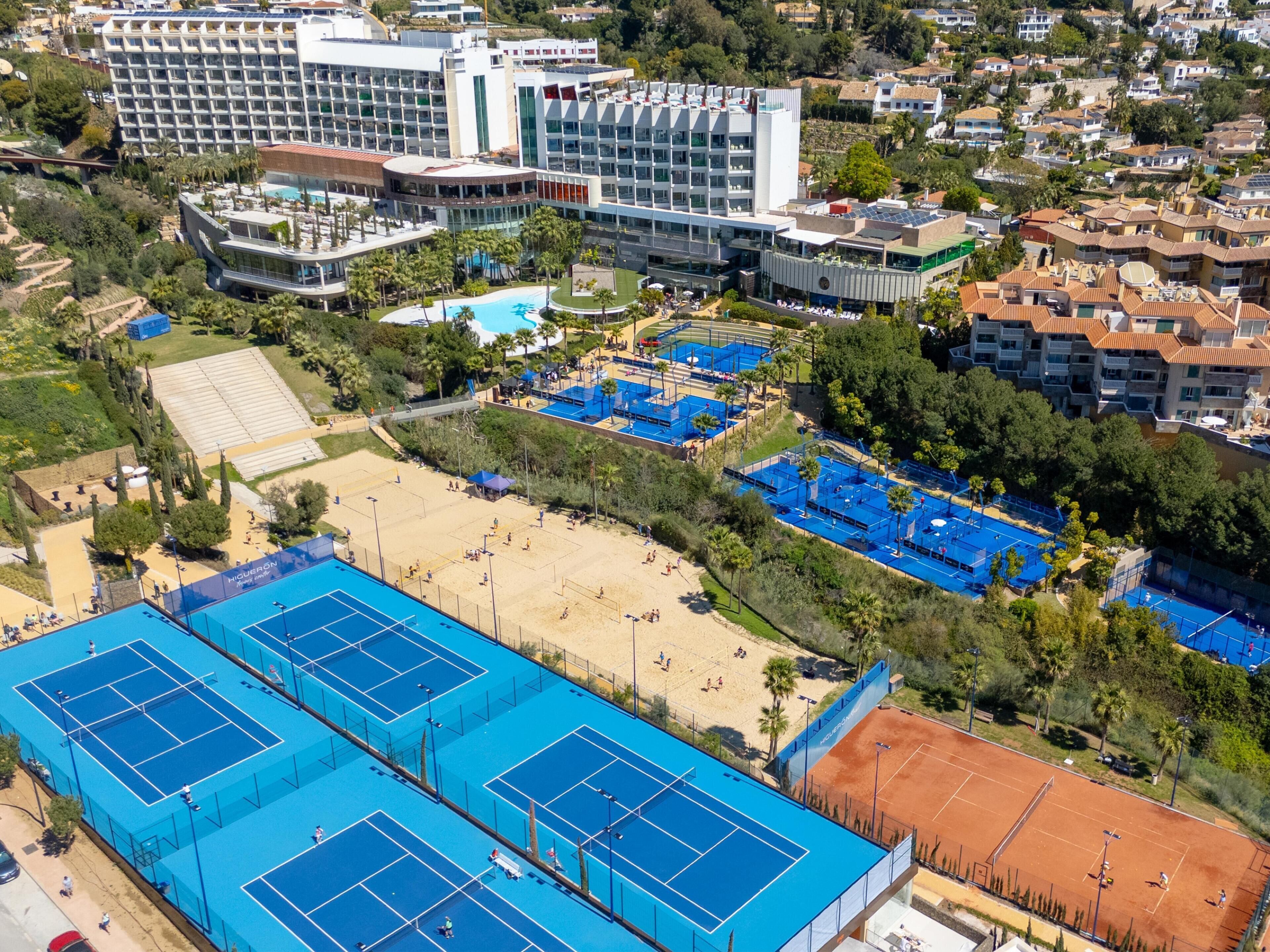 Ein großer Hotelkomplex mit mehreren Gebäuden, einem Tennisplatz und einem Poolbereich.