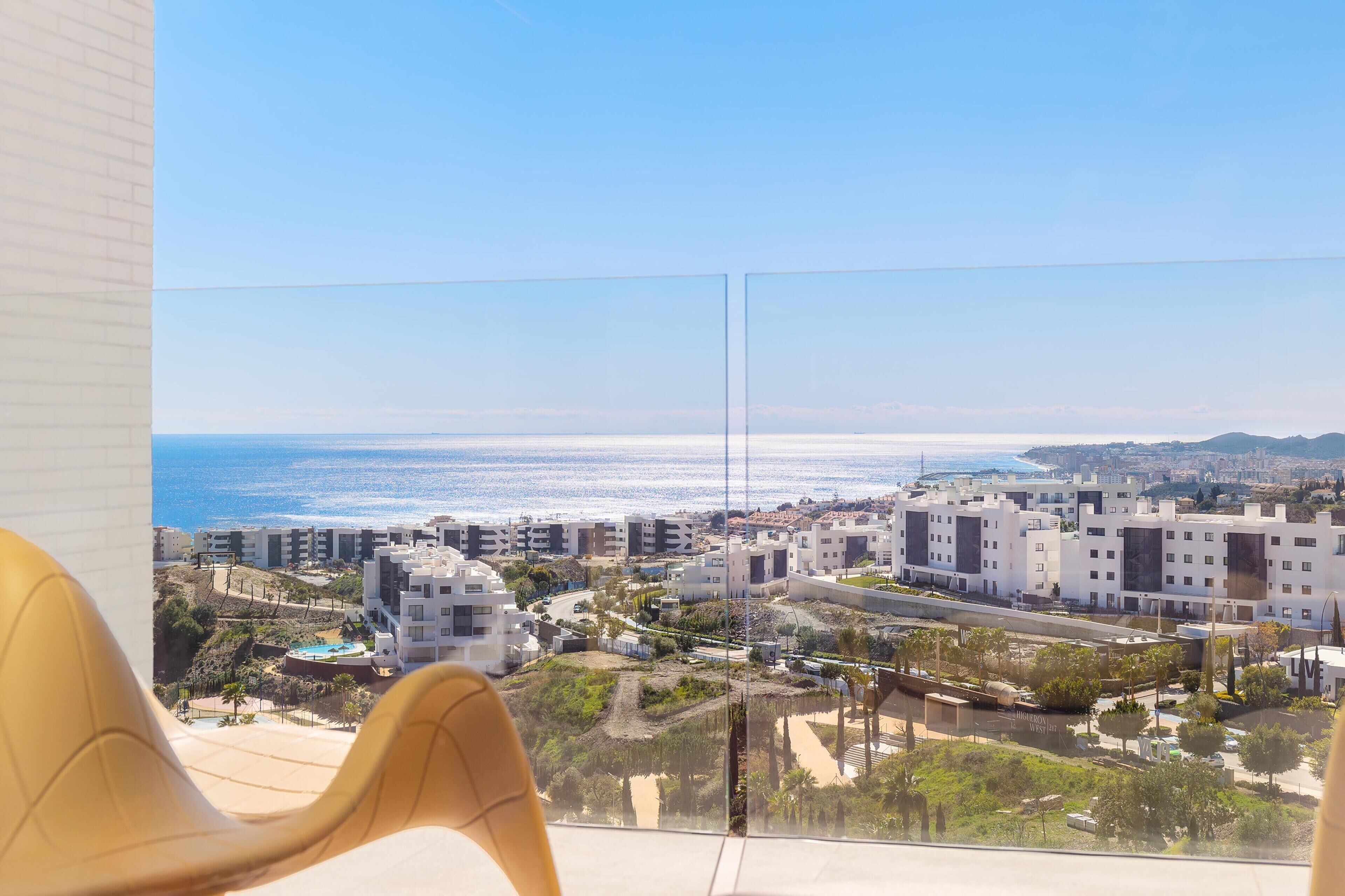 Un balcón con vistas despejadas al océano y una zona residencial.