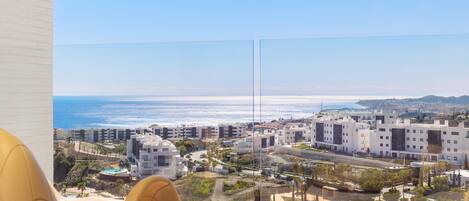 Un balcón con vistas despejadas al océano y una zona residencial.