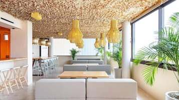 Un interior moderno con techo de materiales naturales, zonas de estar y amplios ventanales.