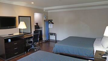 Una habitación de hotel con escritorio, silla, cama y televisión.