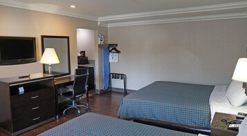 Una habitación de hotel con escritorio, silla, cama y televisión.