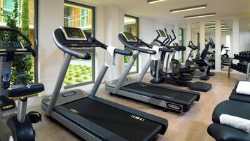 A gym with treadmills, exercise bikes, and dumbbells.