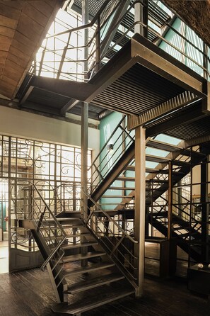A multi-level metal staircase with glass railings and a wooden floor. - San Telmo Suites (Buenos Aires)