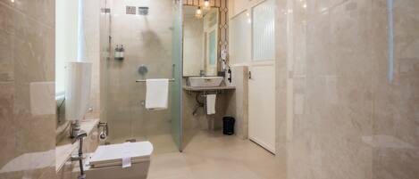 Un baño moderno con ducha de vidrio, una bañera blanca y un lavamanos con espejo.