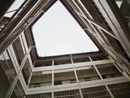 A high-rise building with a central atrium and multiple balconies.