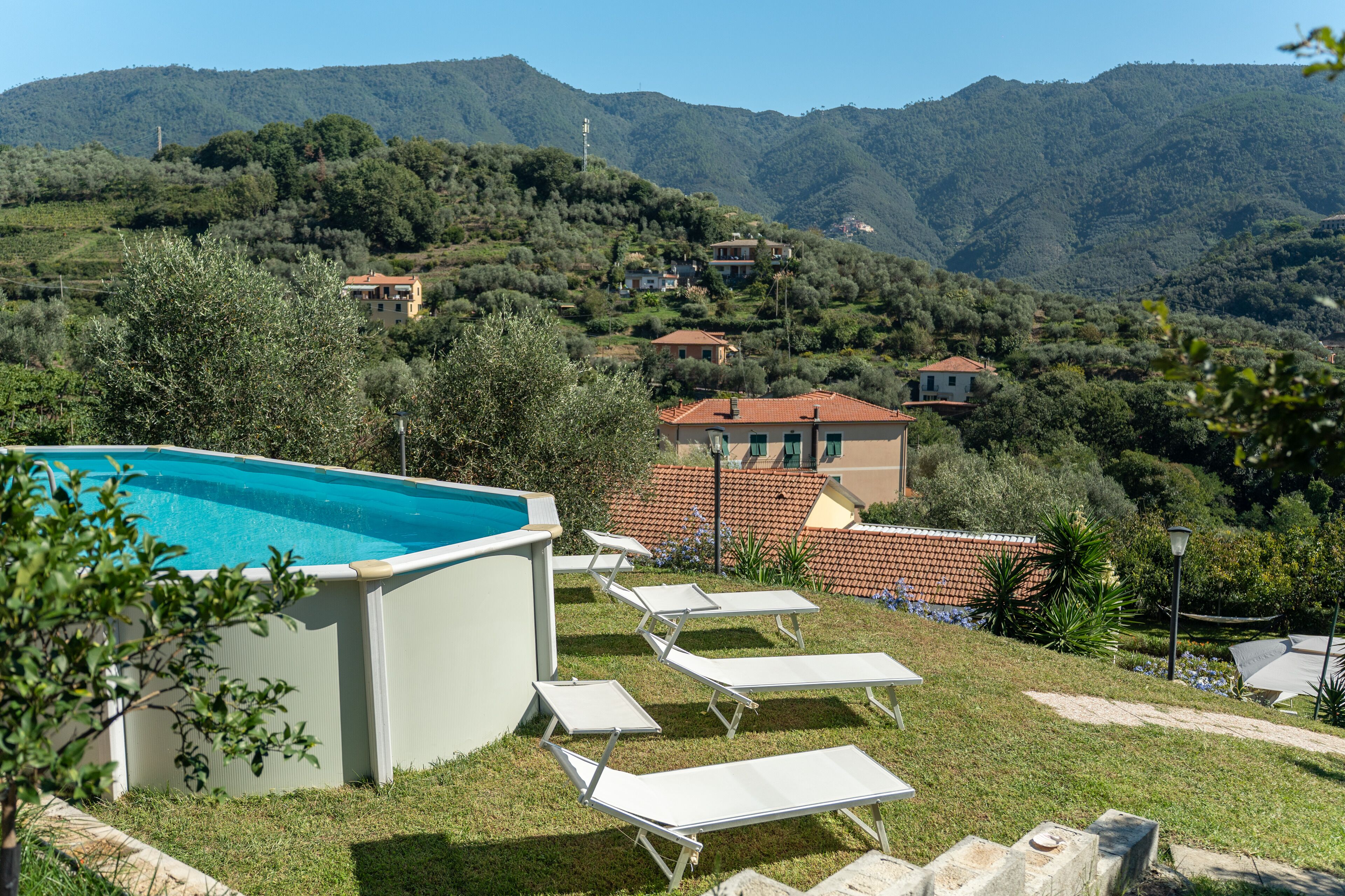 En säsongsöppen utomhuspool, parasoller och solstolar