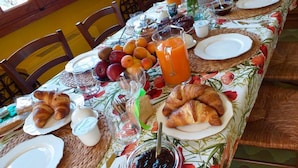 A breakfast table set with croissants, fruits, juice, and jam. - La Finestra sul Mare (Bordighera)