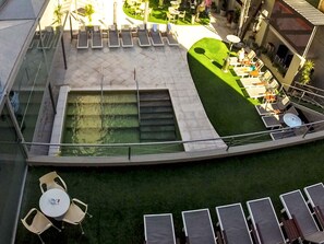 Una piscina techada, una piscina al aire libre, sombrillas