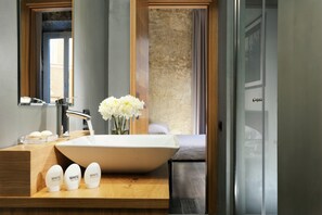 A modern bathroom with a large white sink, a wooden vanity, and a mirror. - Suite Art Navona (Rome)