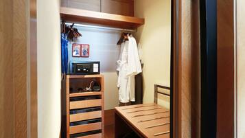 A compact bedroom with a wooden bed, a built-in wardrobe, and a small shelf with a radio.