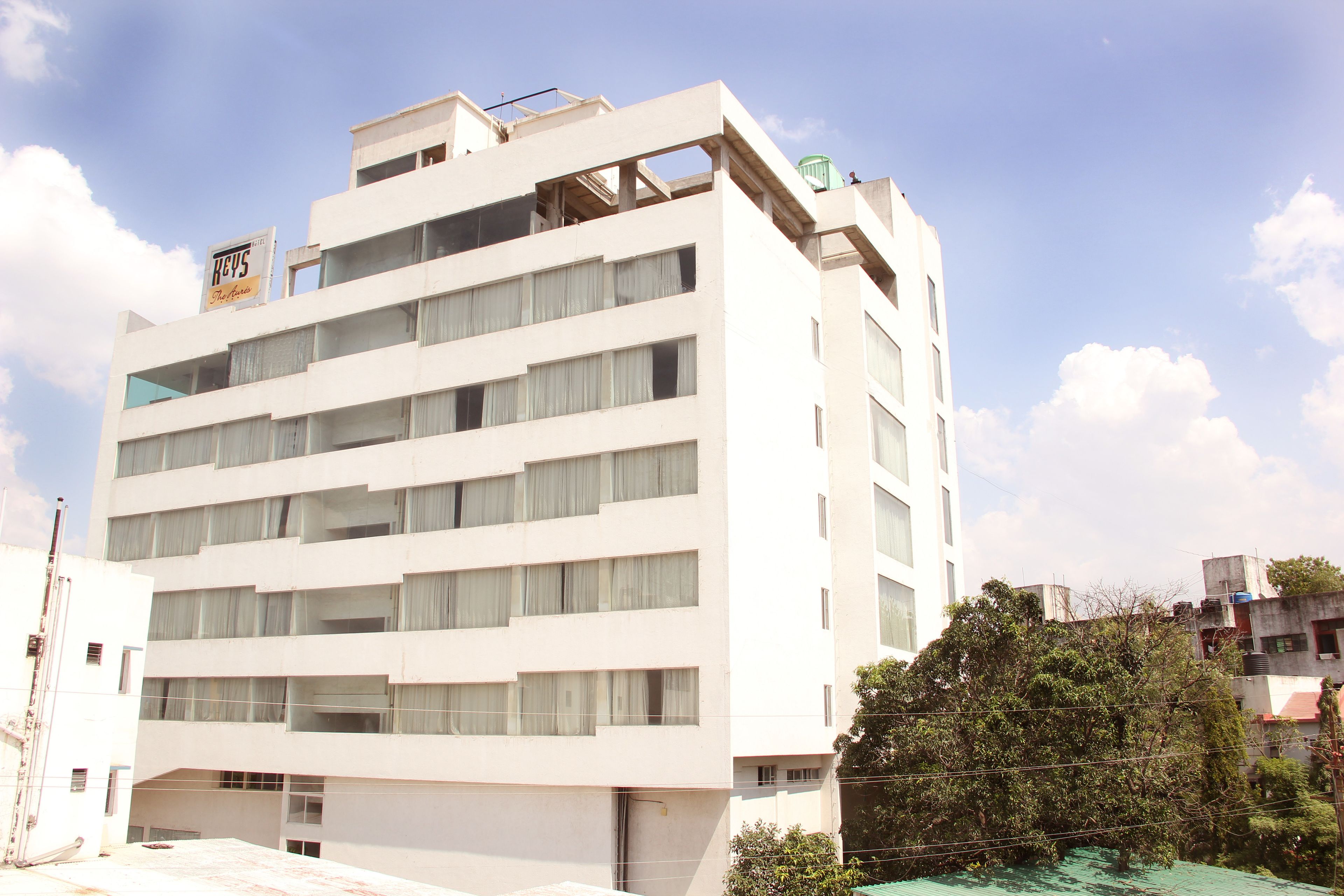 Un edificio de varios pisos con fachada plana, ventanas amplias y un letrero que indica que es un hotel.