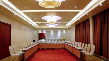 A conference room with a long table, chairs, and a red carpet.