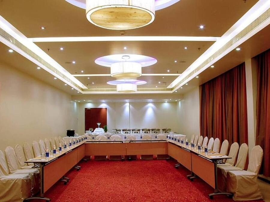 A conference room with a long table, chairs, and a red carpet.